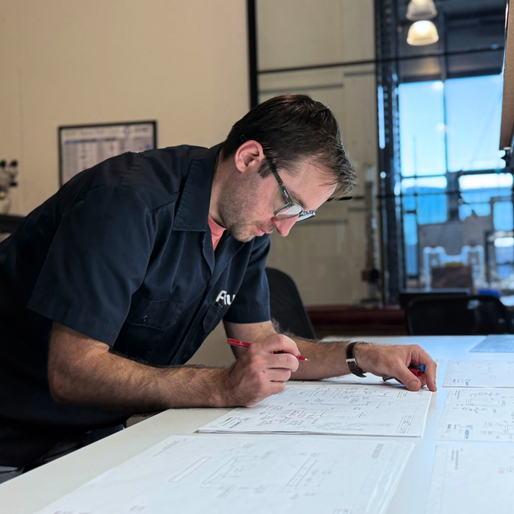 Senior Mechanical Engineer Jason Pfund reviewing CAD layouts for simulator design