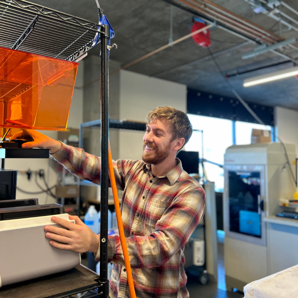 SDS engineer operating SLA printer during prototype fabrication